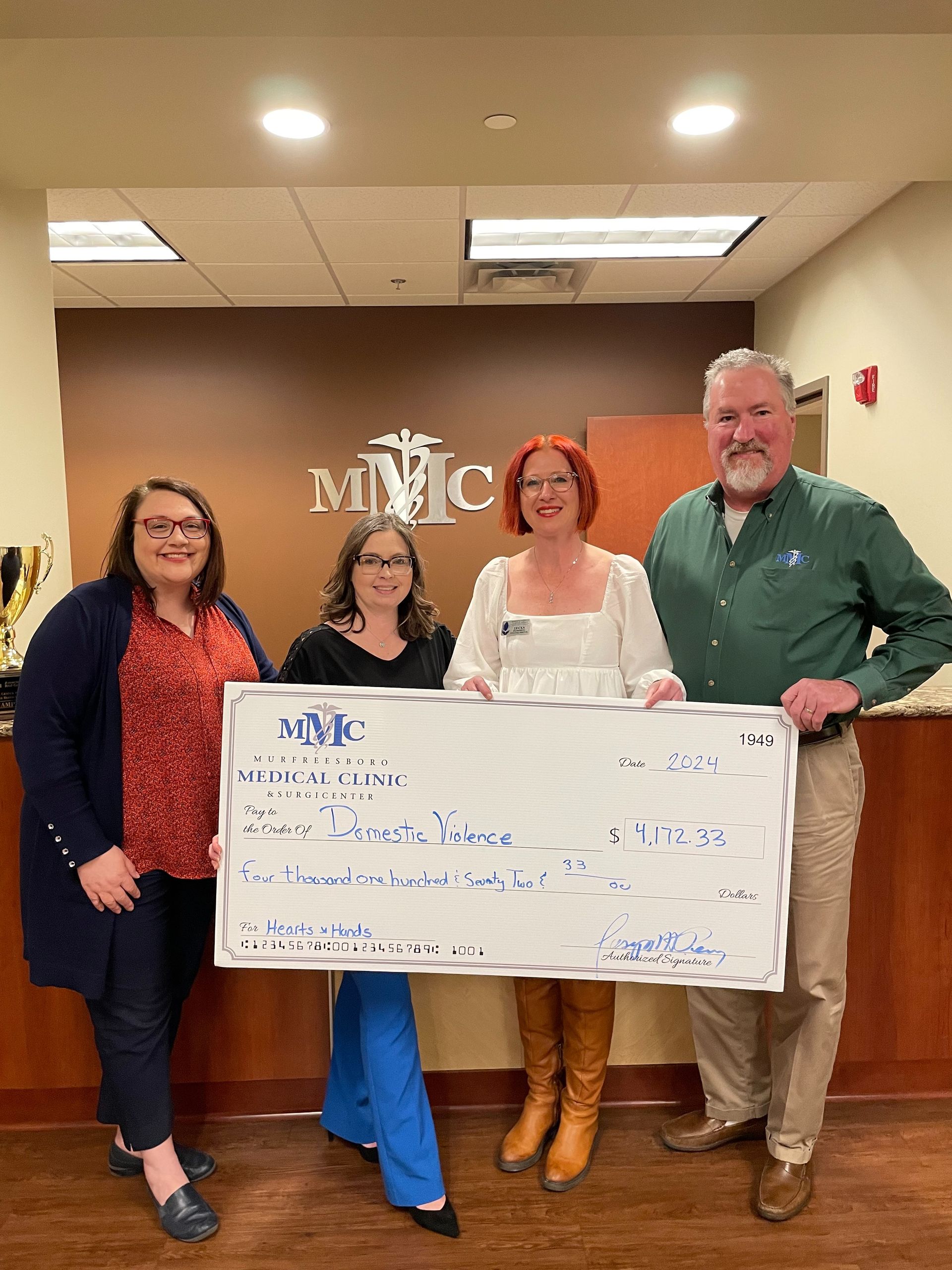A group of people standing next to each other holding a large check.