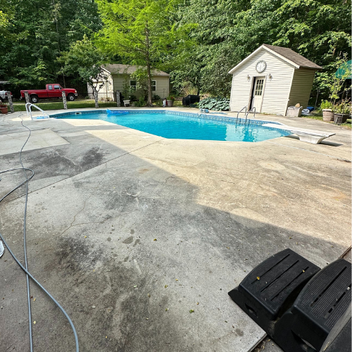 There is a large swimming pool in the backyard of a house.