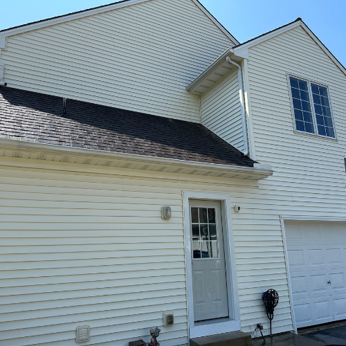 A white house with a black roof and a white door