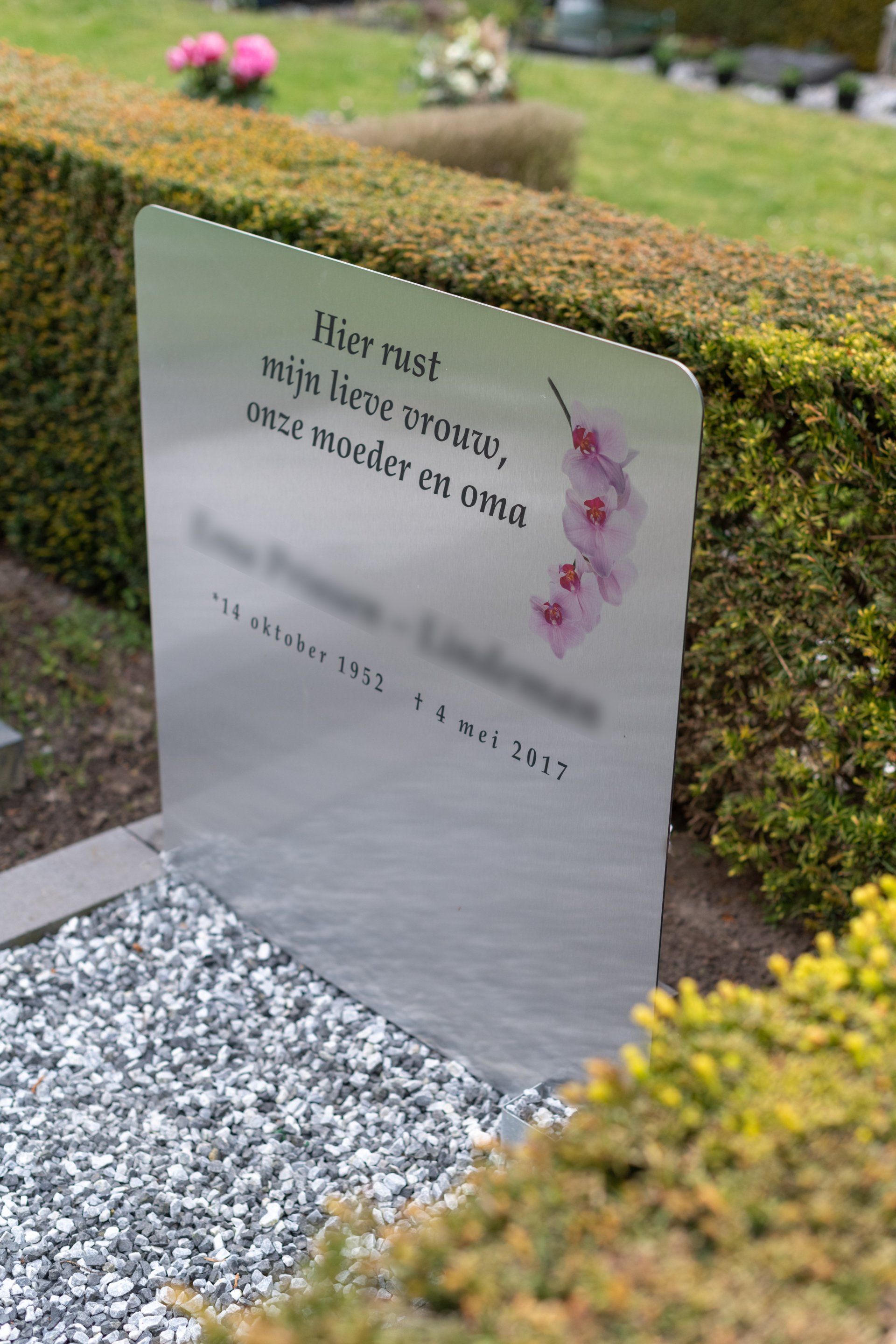 Grafmonument. Een grafsteen met een gedicht erop staat op een kerkhof.