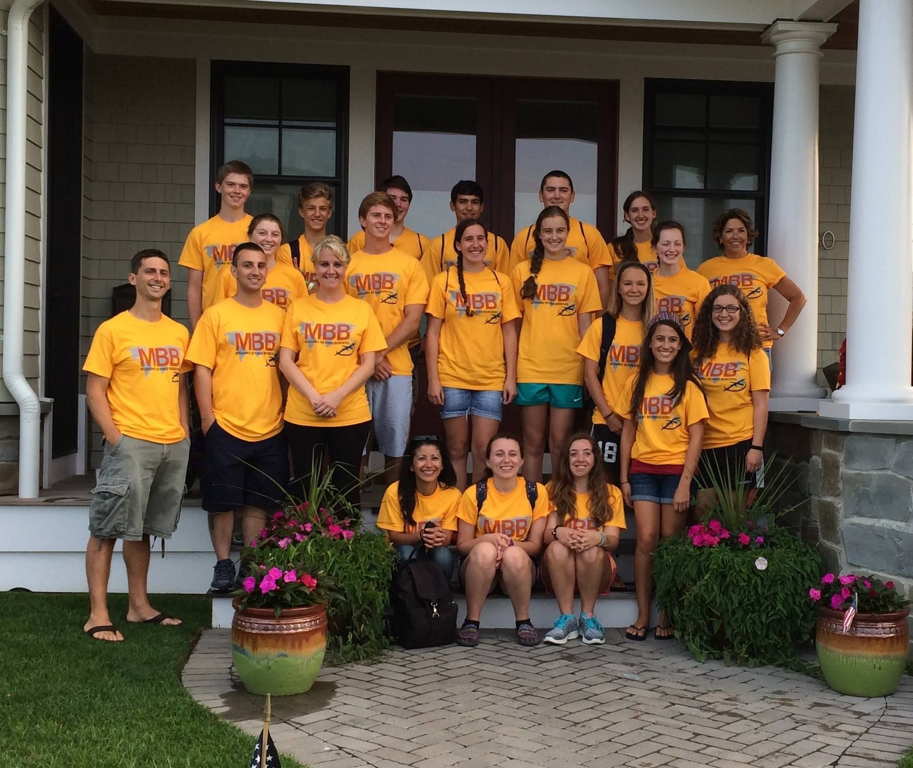 A group of people are posing for a picture in front of a house