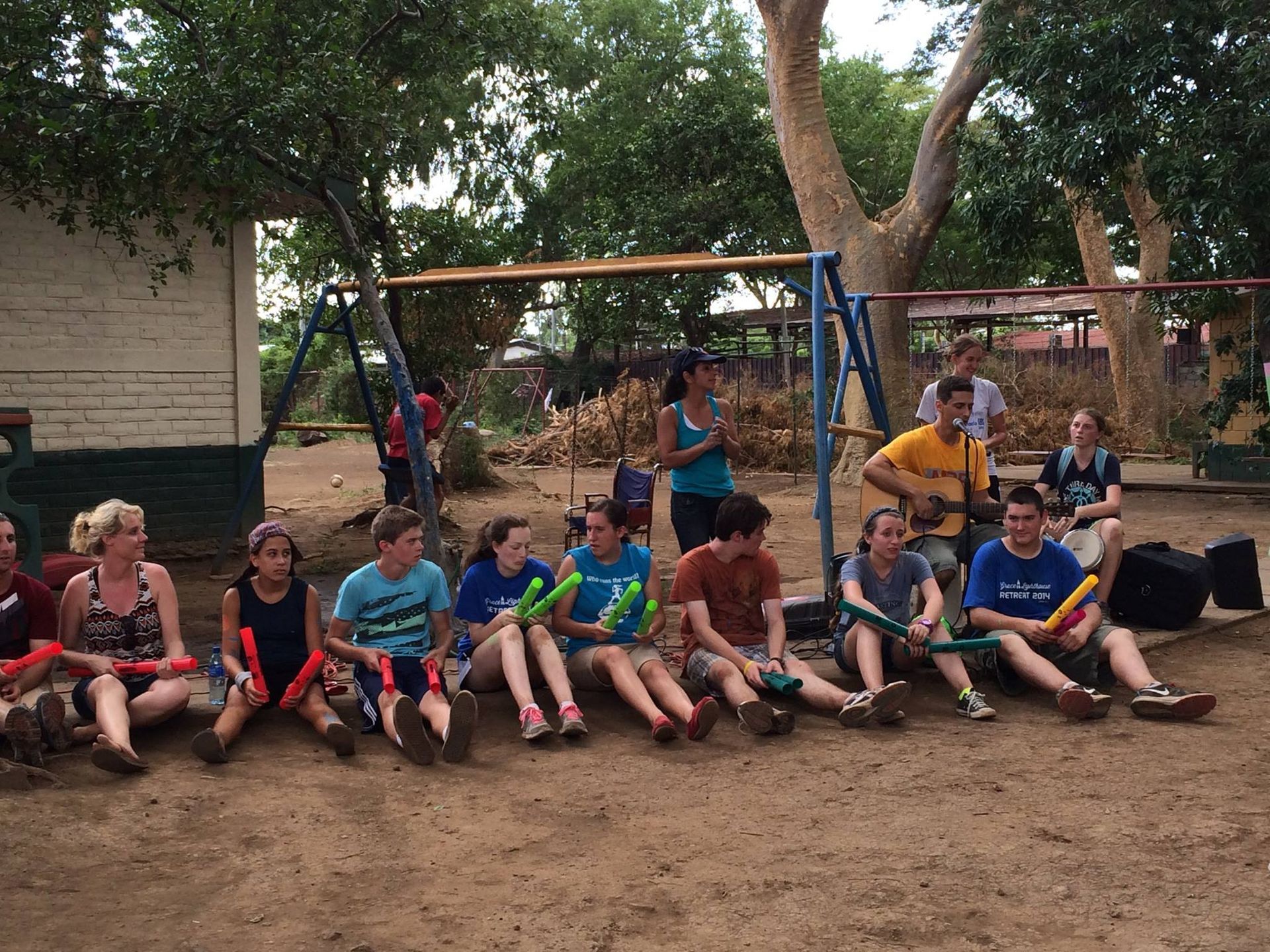 A group of people are sitting on the ground in a park