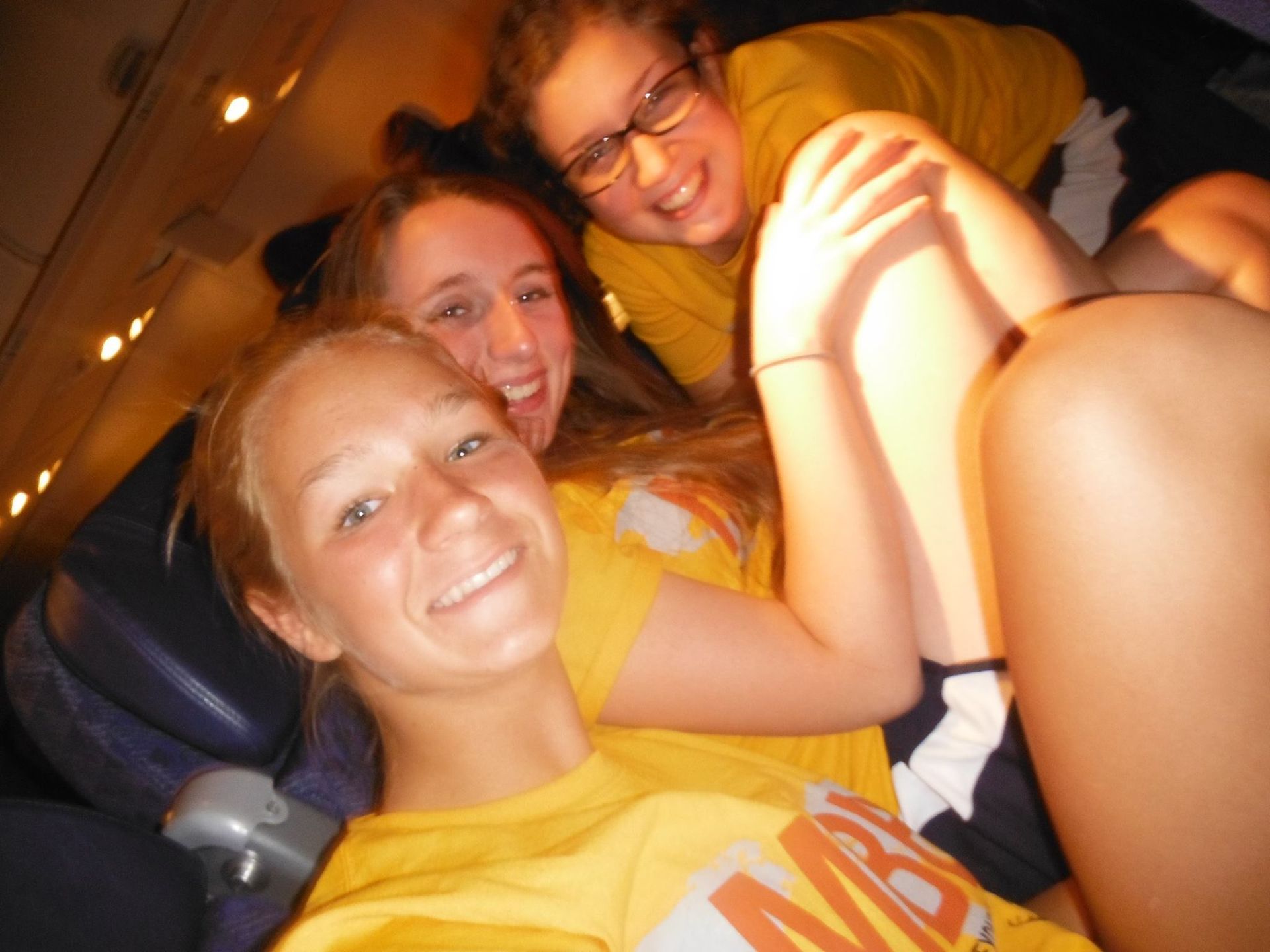 A girl wearing a yellow shirt with the letter m on it