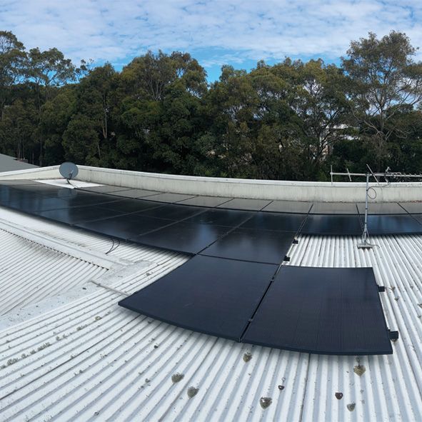A White Roof With Black Solar Panels on It — DLG Electrical & Solar In Wyong, NSW