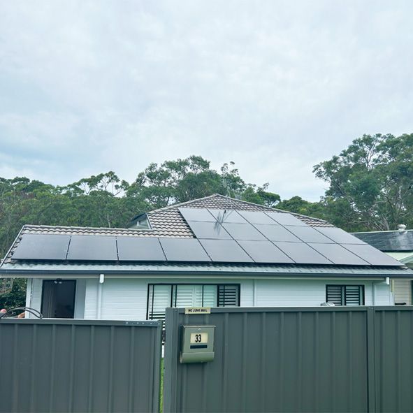 A House With a Fence and Solar Panels on the Roof — DLG Electrical & Solar In Wyong, NSW