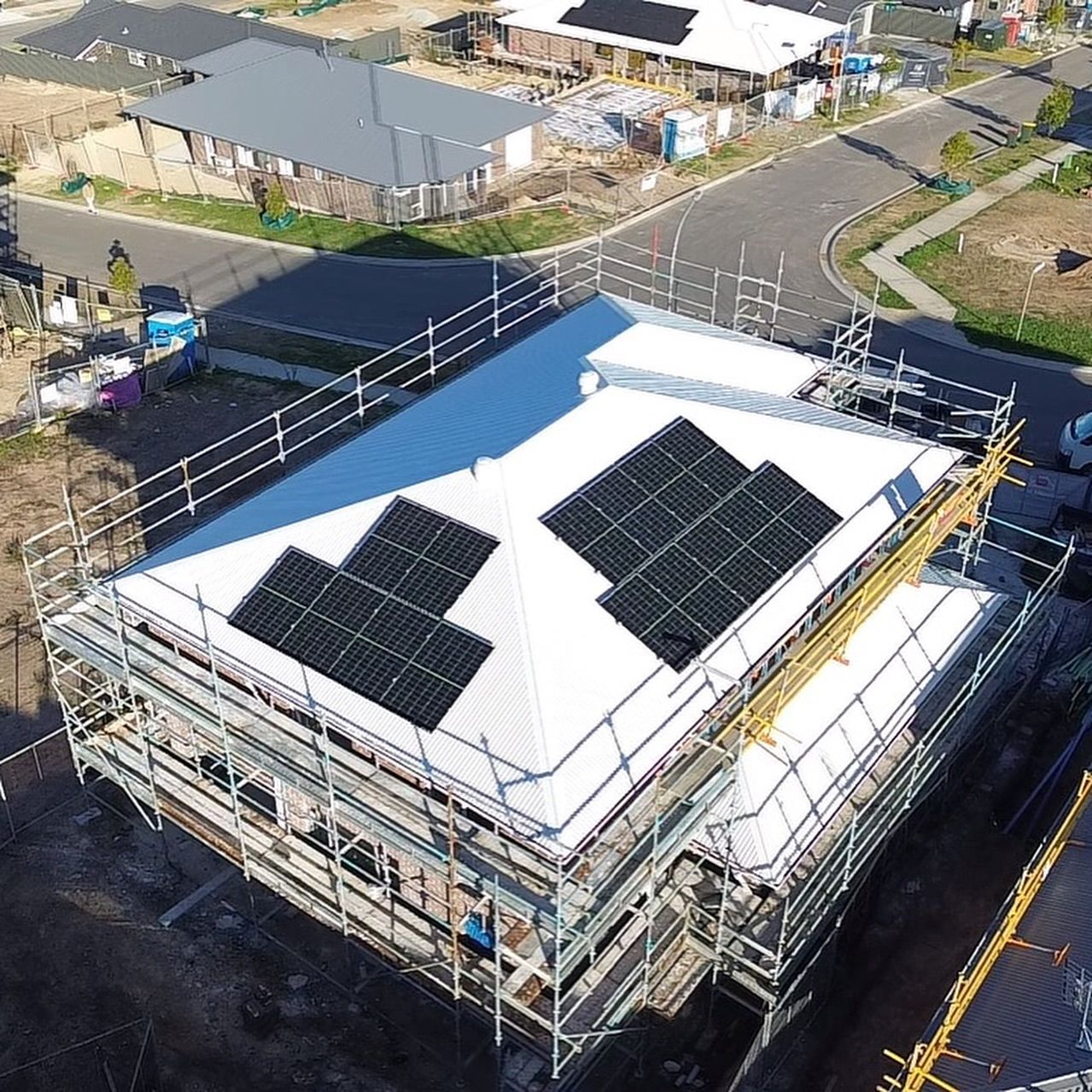 An Aerial View of a White House With Solar Panels on the Roof — DLG Electrical & Solar In Wyong, NSW