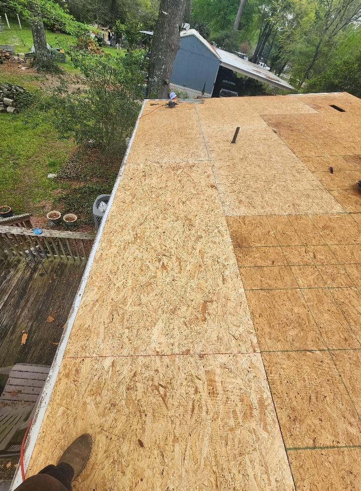 A person is standing on top of a wooden roof.