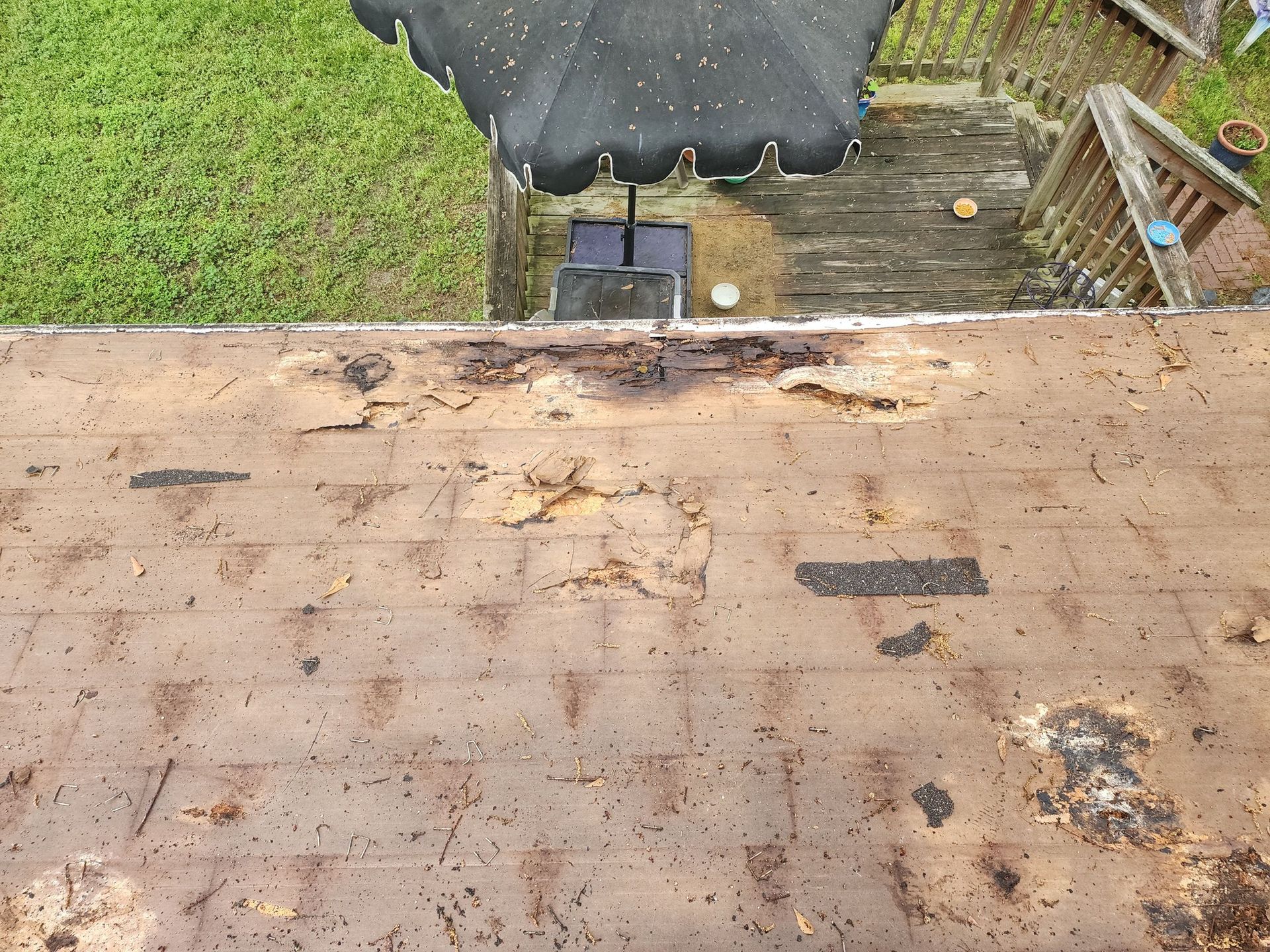 A roof with a black umbrella on top of it