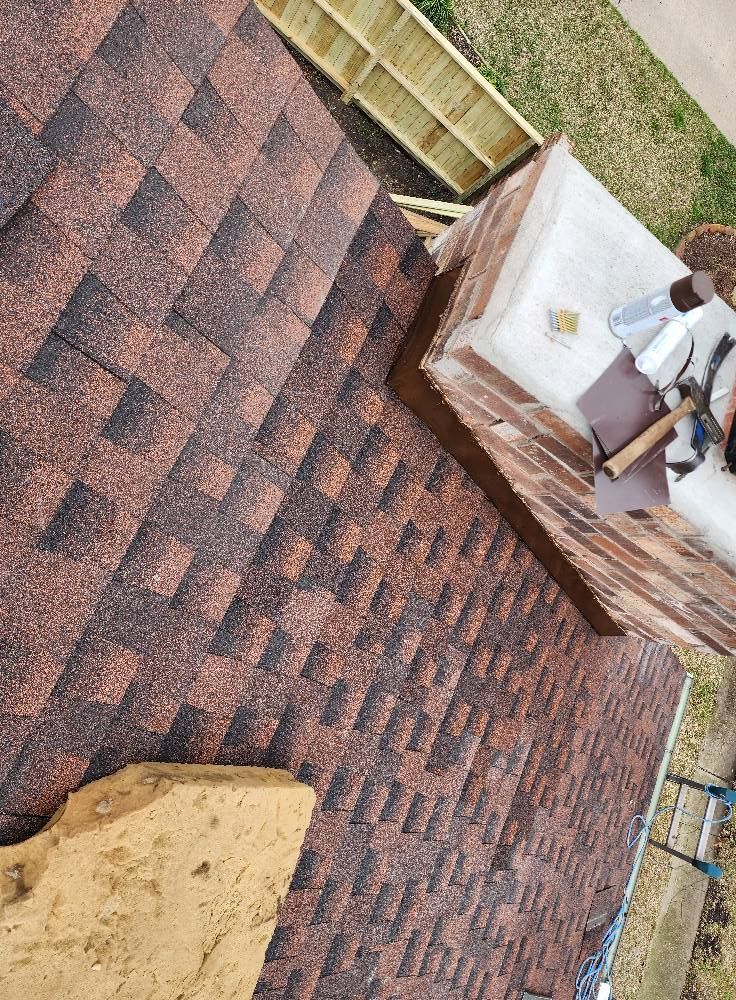 An aerial view of a roof with shingles being installed.