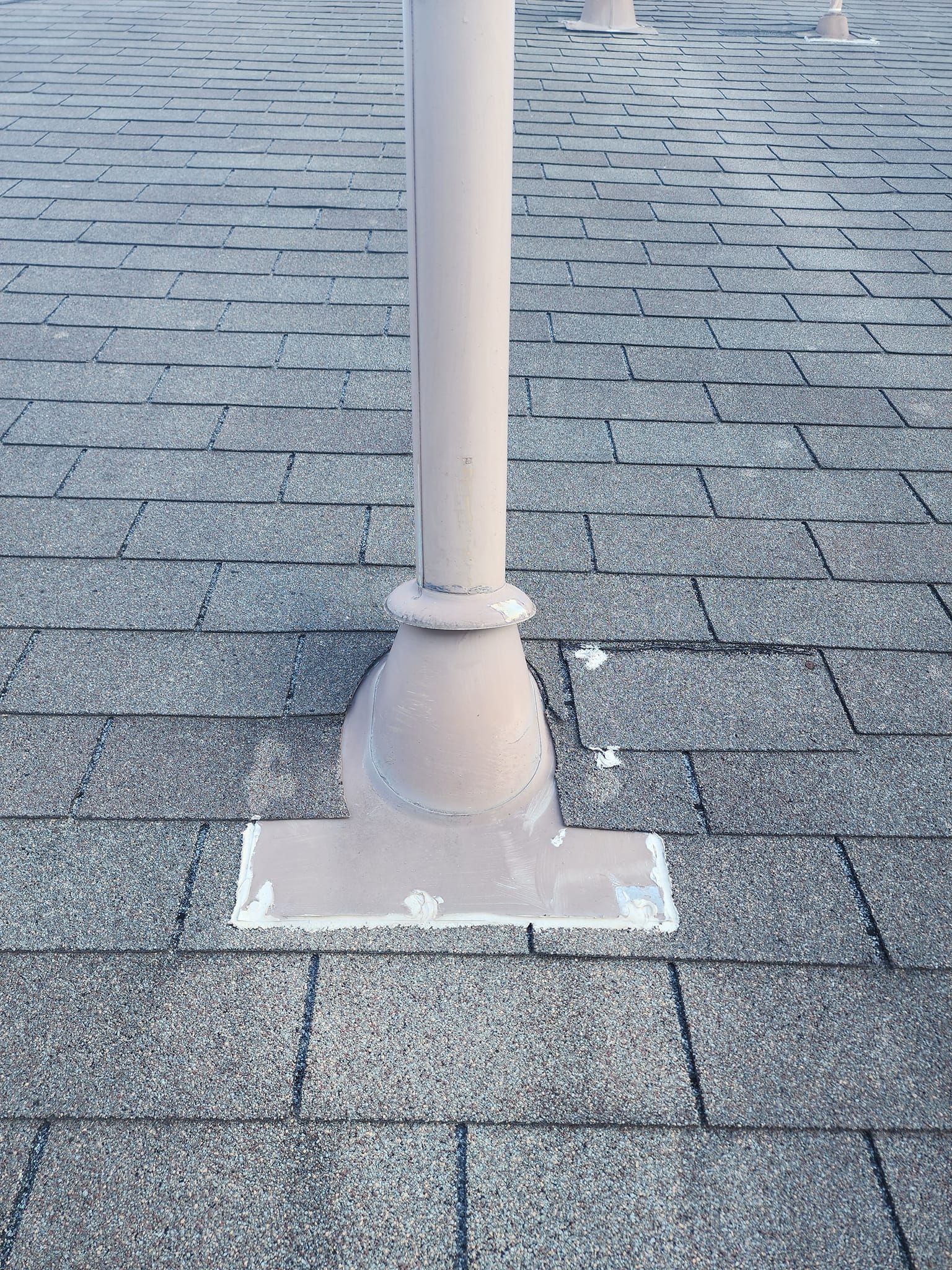 A white pole is sitting on a brick pavement.
