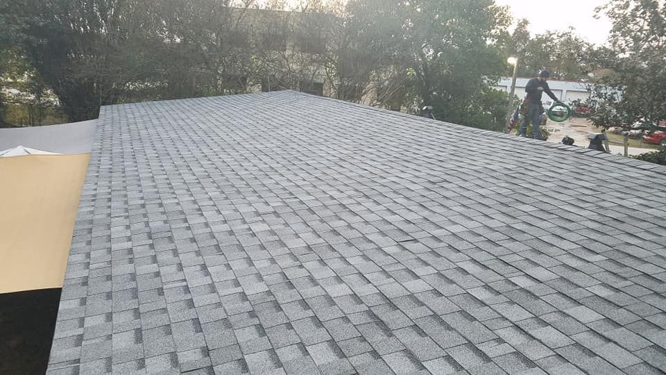 A man is working on the roof of a house.