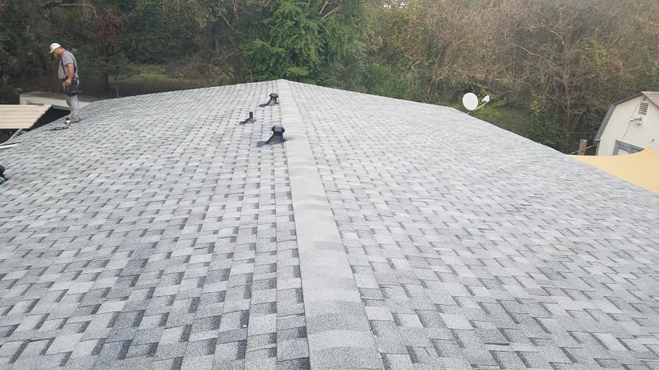 A man is working on the roof of a house.