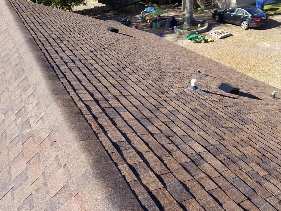 An aerial view of a roof with a car parked on the side of it.