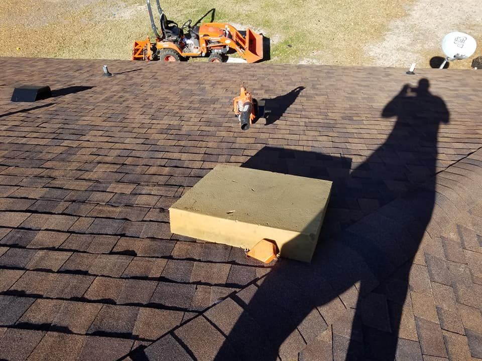 A shadow of a person is cast on the roof of a house
