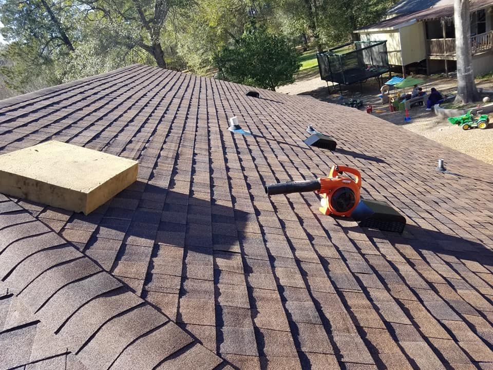 A blower is sitting on the roof of a house.