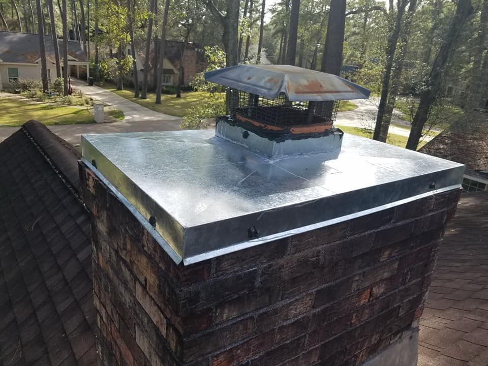 A brick chimney with a metal cap on top of it.