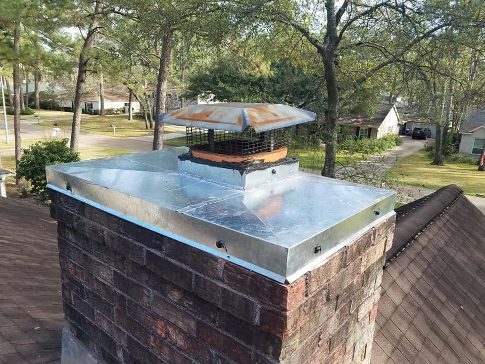 A brick chimney with a metal cap on top of it.
