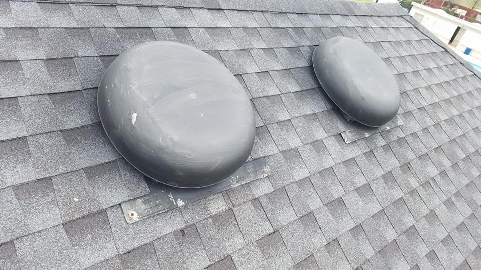 There are two vents on the roof of a house.