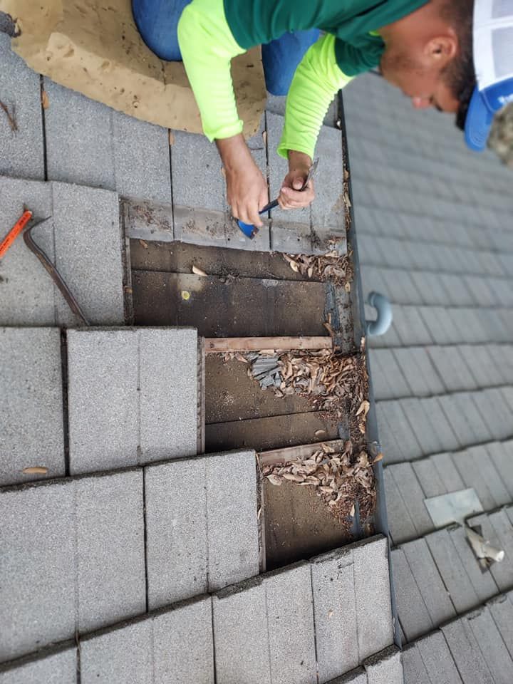 A man is working on a roof with a screwdriver
