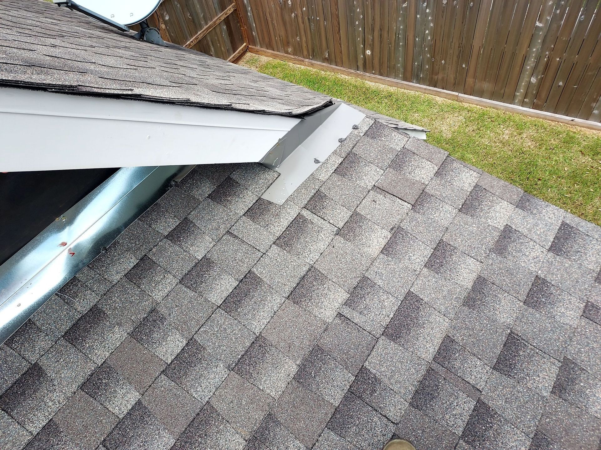 A close up of a roof with shingles and a window.