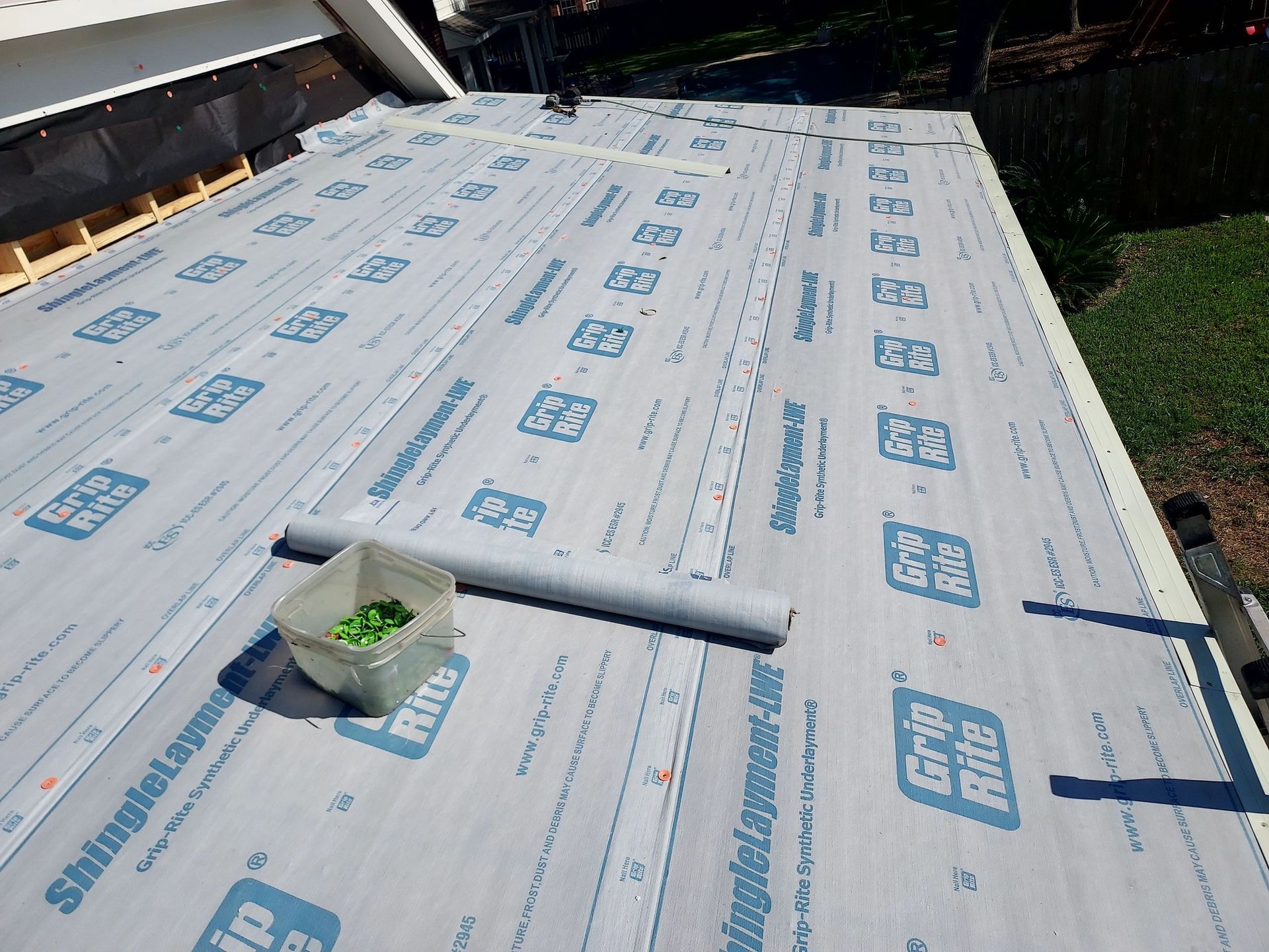 A roof is being covered with a roofing material.