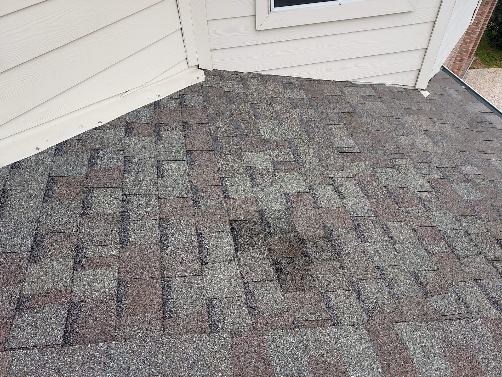 A close up of a roof with a window in the background.