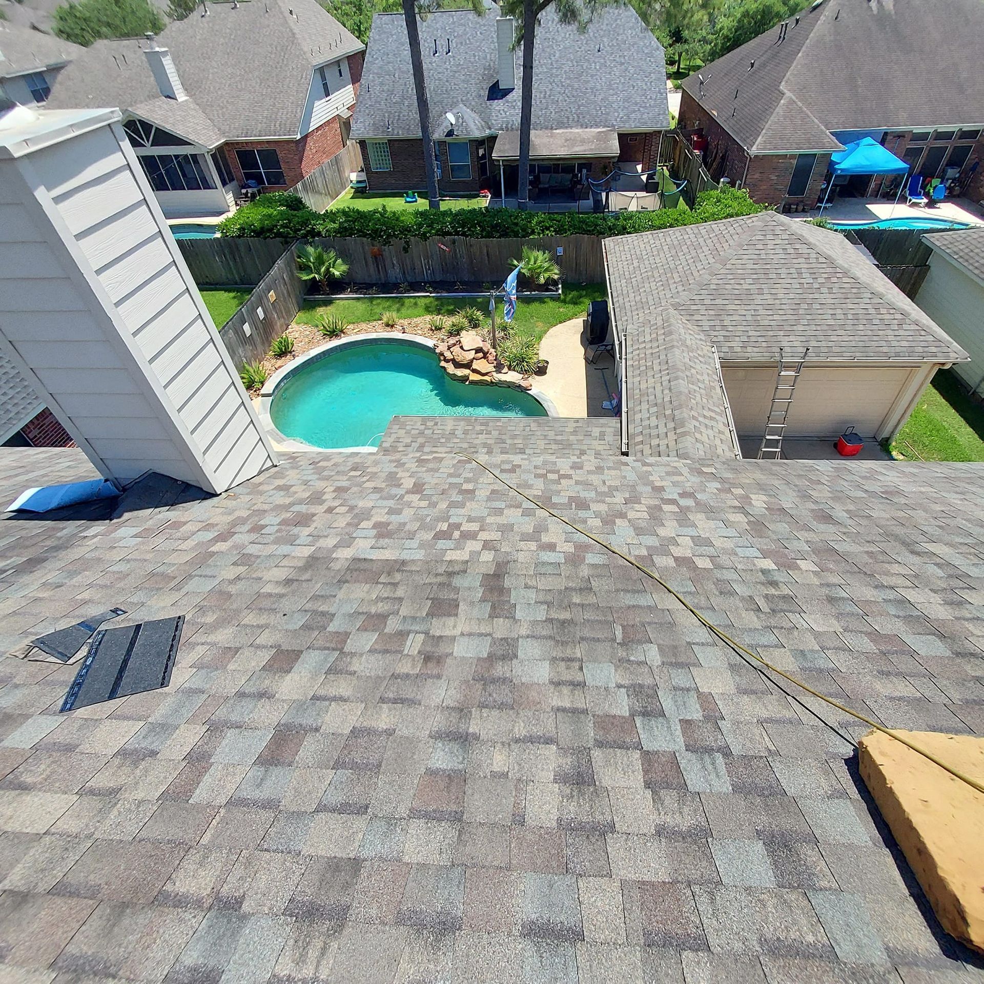 An aerial view of a roof with a pool in the backyard.