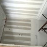 A room with a striped ceiling and a wooden shelf.