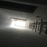 Looking up at a staircase in a building with a light coming through the window.