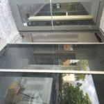 A glass door with a reflection of a building in it.