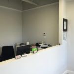 A reception area in a hospital with a desk and chairs.