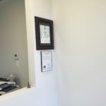 A picture frame is hanging on a white wall in a room.