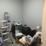 A room filled with lots of junk and a ladder.