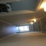 A very long hallway with a lot of windows and a ceiling.