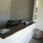 There is a counter in the middle of the room with a computer on it.