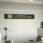 There is a sign on the wall that says `` livescan labs ''.