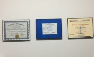 Three framed certificates are hanging on a wall.