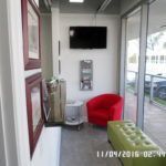 A waiting room with a red chair and a green bench.