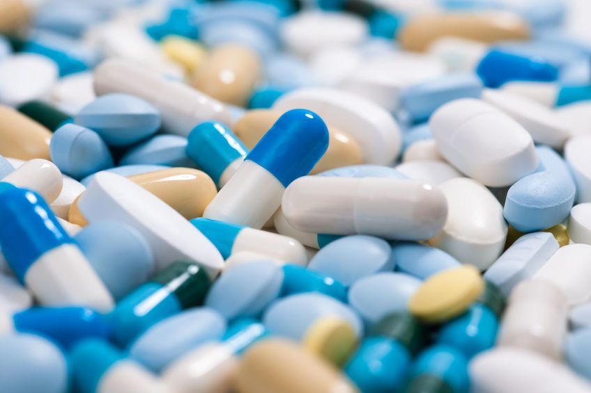 A pile of blue and white pills and capsules