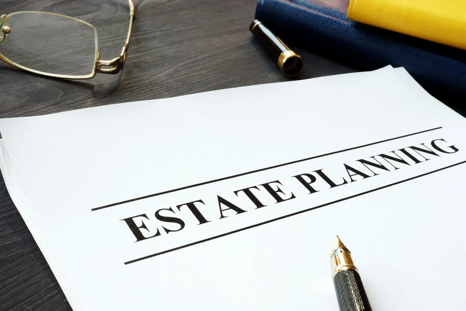 A pen is sitting on a piece of paper that says estate planning