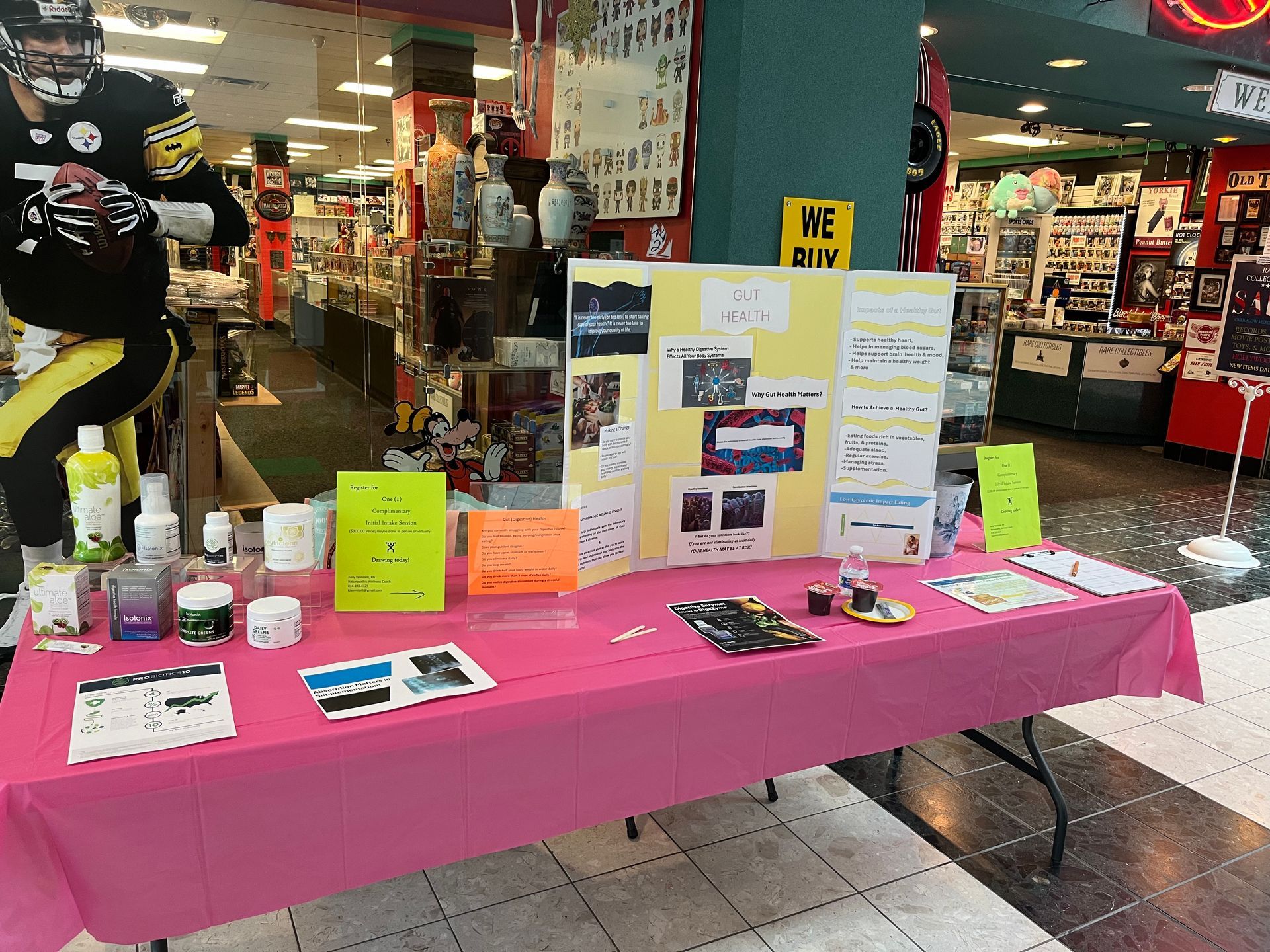 A table with a pink table cloth and a yellow sign that says ne div