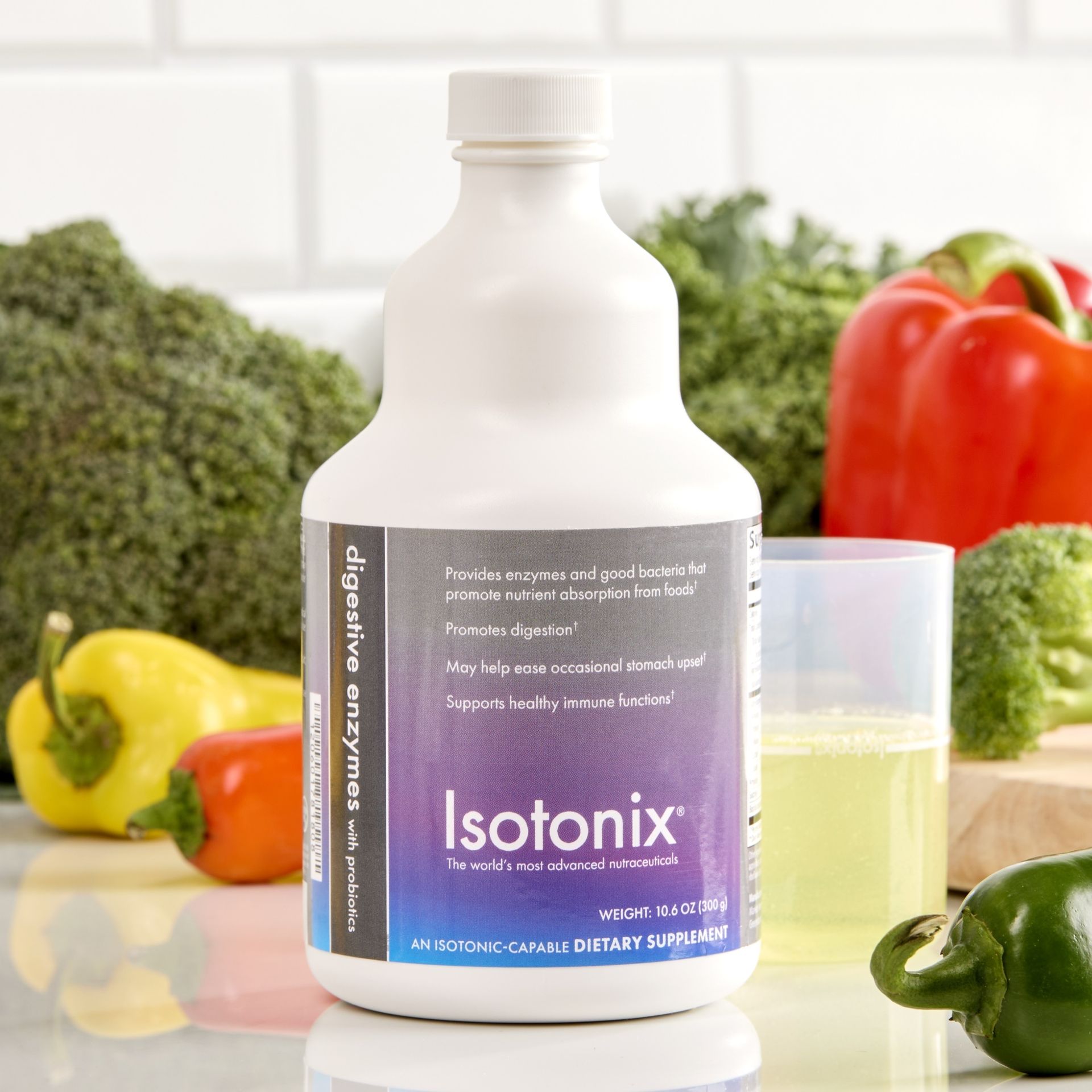 A bottle of isotonix sits on a counter in front of vegetables