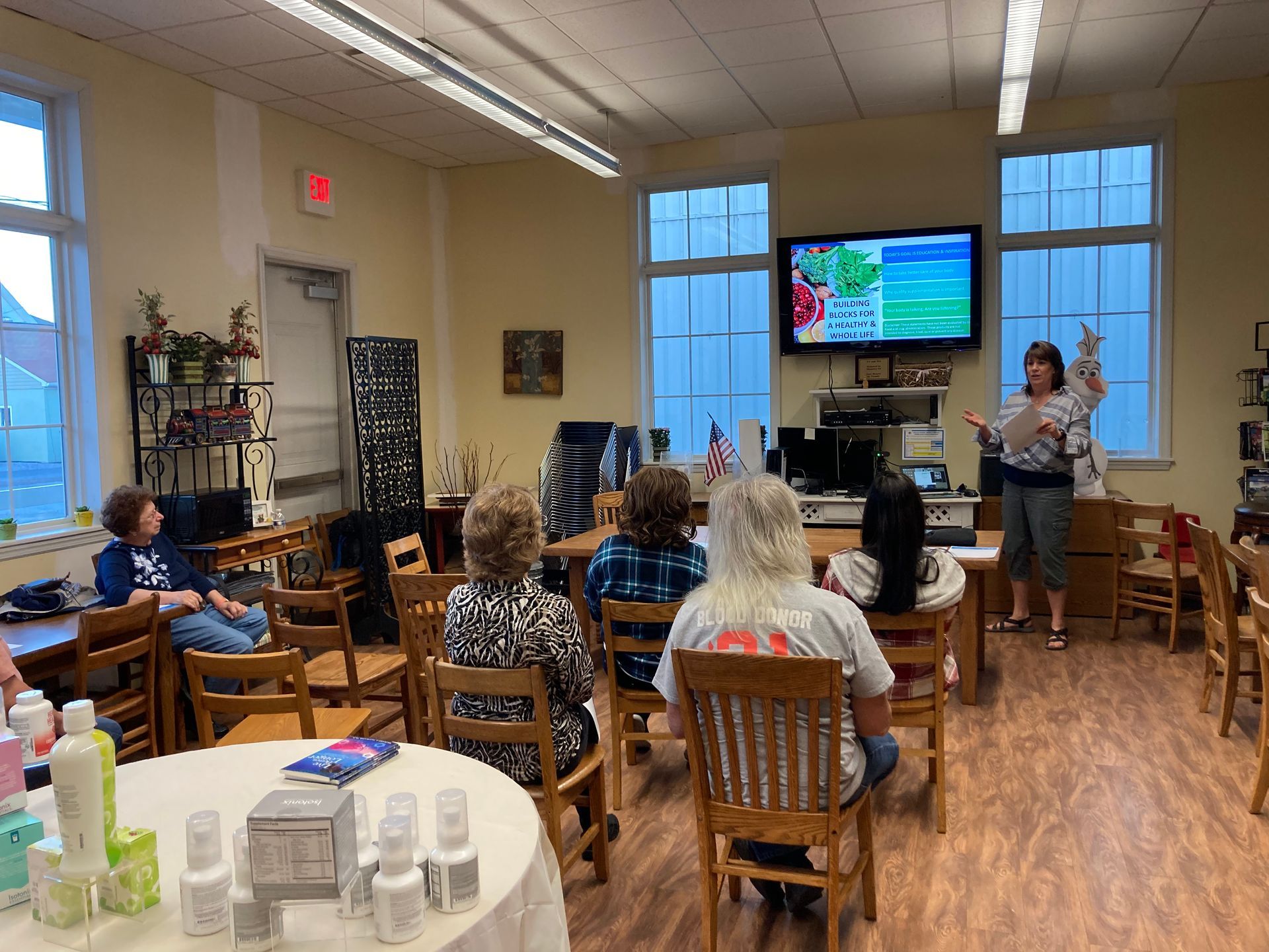 A woman is giving a presentation to a group of people in a room.