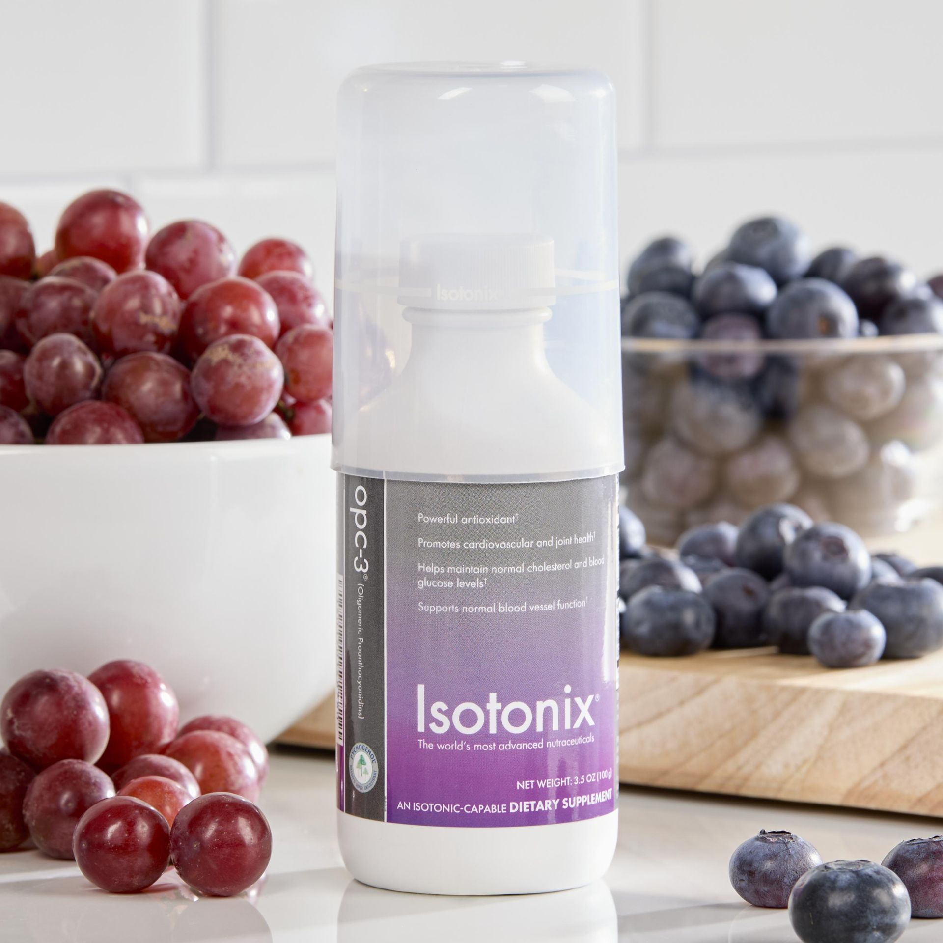 A bottle of isotonix next to a bowl of grapes