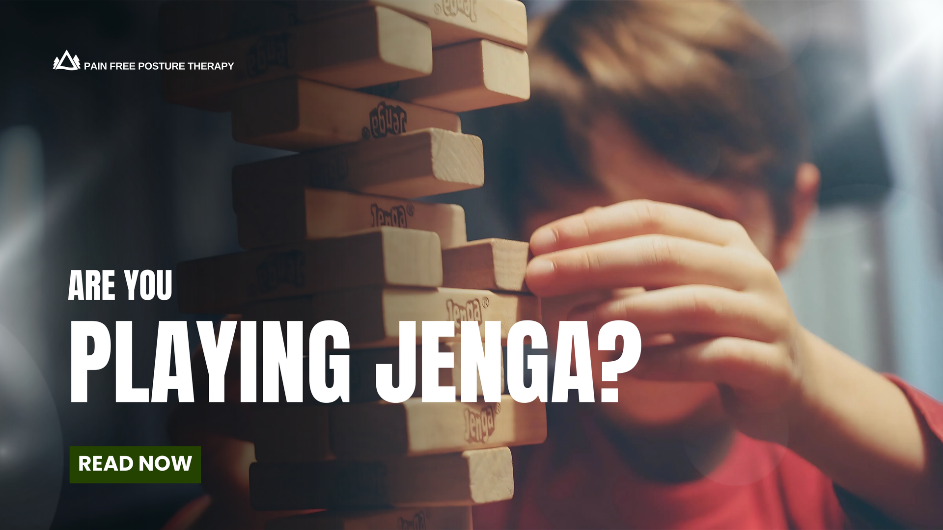 A young boy is playing a game of jenga with wooden blocks.