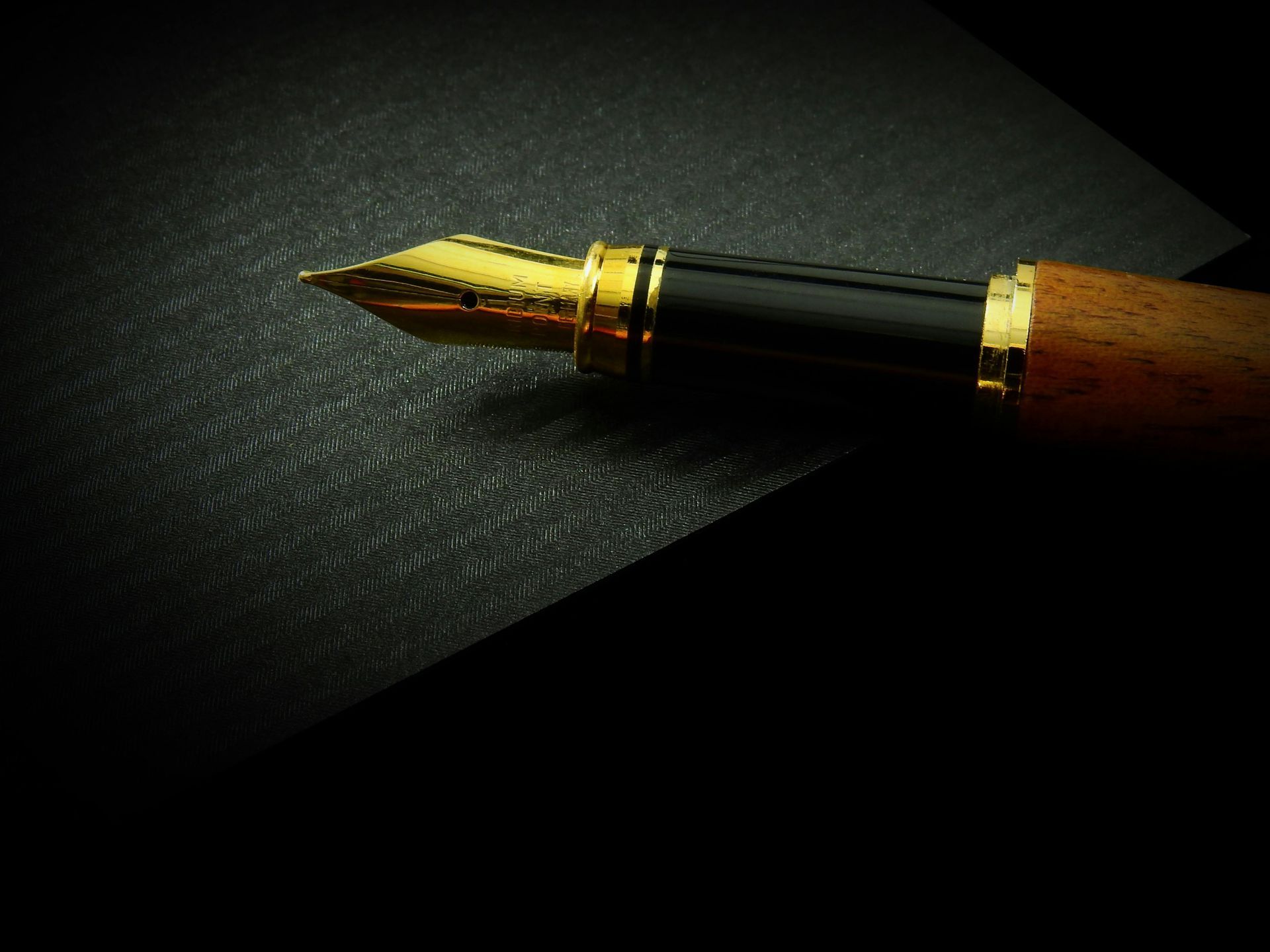 A close up of a fountain pen on a black surface