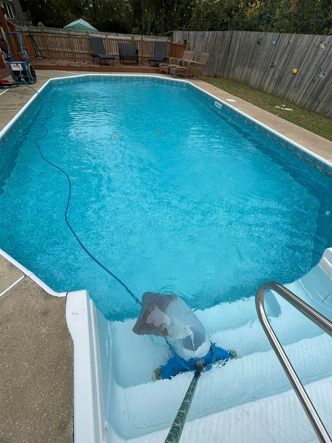 Wide Pool and Wooden Fence in Backyard