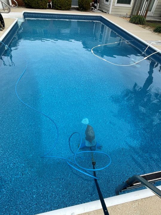 Worker Cleaning the Outdoor Swimming Pool