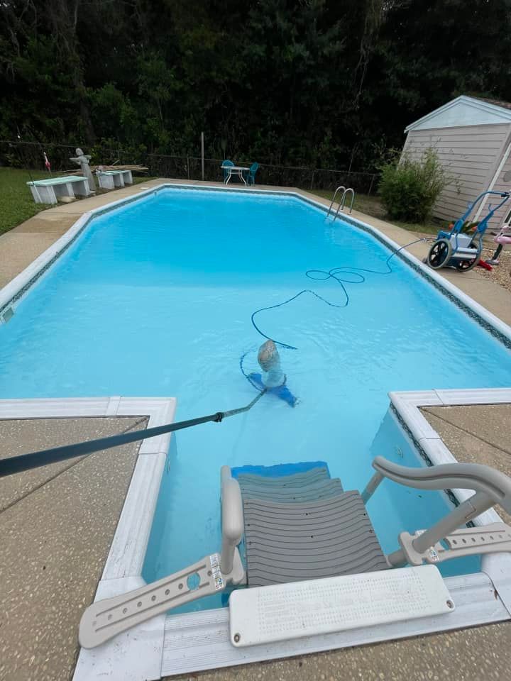 Cleaning a Wide Swimming Pool in a Backyard