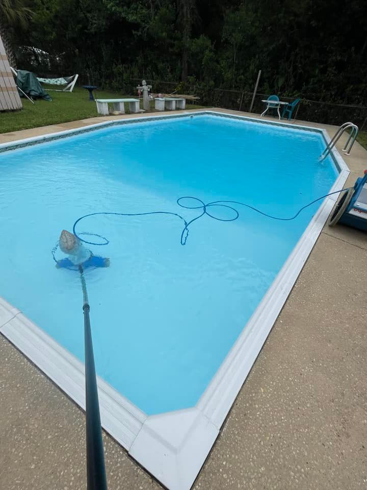 A Pool Being Vacuumed with Blue Hose
